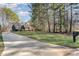 Spacious property featuring a long driveway, a well-manicured lawn, and a charming two-story home nestled among tall trees at 125 Cherokee Dr, Mooresville, NC 28117