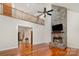 Open-concept living room with stone fireplace, hardwood floors, and second story loft at 125 Cherokee Dr, Mooresville, NC 28117