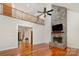 Open-concept living room with stone fireplace, hardwood floors, and second story loft at 125 Cherokee Dr, Mooresville, NC 28117