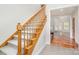 Elegant staircase featuring carpeted steps and a wooden railing, leading towards the bright, open living area at 125 Cherokee Dr, Mooresville, NC 28117