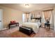 Comfortable bedroom with neutral colors, carpet, side tables, curtains and a bench seat at 15309 Guthrie Dr, Huntersville, NC 28078