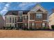 Charming two-story home boasts a mix of brick and siding, complemented by lush landscaping at 15309 Guthrie Dr, Huntersville, NC 28078