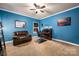 Blue home office with large desk, ceiling fan, brown sofa and carpeted floors at 15309 Guthrie Dr, Huntersville, NC 28078