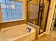 Bathroom with soaking tub and separate glass-enclosed shower with tiled surround at 1726 Still River Way, Fort Mill, SC 29708