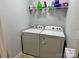 Bright laundry room featuring a white washer and dryer and convenient shelving for storage at 1726 Still River Way, Fort Mill, SC 29708
