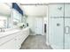 Well-lit bathroom featuring double vanity sinks, a walk-in shower with glass door, and modern tile flooring at 1813 Ab Moore Jr Dr # 3239, Indian Trail, NC 28079