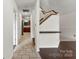 Interior hallway with neutral tile flooring, wooden staircase, and sightlines to the kitchen at 200 W 18Th St, Newton, NC 28658