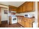 Traditional kitchen featuring wooden cabinets, white appliances, and floral wallpaper at 2408 Winterfield Dr, Gastonia, NC 28056