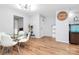 Dining room features hardwood floors, a glass table, and a large wall clock at 2900 Heathstead Pl # H, Charlotte, NC 28210