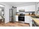 Well-lit kitchen features stainless steel appliances, butcher block countertops, and white cabinetry at 2900 Heathstead Pl # H, Charlotte, NC 28210