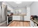 Modern kitchen with stainless steel appliances, white cabinets, and wood floors at 2900 Heathstead Pl # H, Charlotte, NC 28210