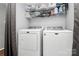 Laundry room with a white washer and dryer and storage shelves at 2900 Heathstead Pl # H, Charlotte, NC 28210