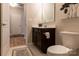 Well-lit bathroom with wood-look floors, decorative mirror, and dark vanity at 3156 Pinehills Way, Mount Holly, NC 28120