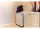 Functional laundry room with modern washer and dryer units and shelving at 3156 Pinehills Way, Mount Holly, NC 28120