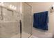 Clean shower featuring marble-look tile, glass surround, and built in niche at 3156 Pinehills Way, Mount Holly, NC 28120