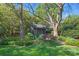 Quaint backyard shed surrounded by lush landscaping, featuring a gray wood exterior and garden path at 332 Hempstead Pl, Charlotte, NC 28207