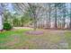 Large backyard with mature trees and a birdhouse offers a serene outdoor space at 340 Tradewinds Ln, York, SC 29745