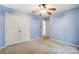 Cozy bedroom with blue walls, carpet floors, closet and a door, providing ample storage and accessibility at 340 Tradewinds Ln, York, SC 29745