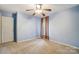 Bedroom with blue walls and neutral carpet featuring a ceiling fan and a window with curtains at 340 Tradewinds Ln, York, SC 29745