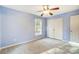 Blue bedroom featuring a ceiling fan, neutral carpet, a window, and a white closet at 340 Tradewinds Ln, York, SC 29745