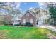 Well-maintained brick home featuring a detached garage and a lush, green lawn with mature trees surrounding the property at 340 Tradewinds Ln, York, SC 29745
