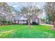 Traditional brick home featuring a lush green lawn, mature trees, and a classic facade with blue shutters at 340 Tradewinds Ln, York, SC 29745