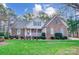 Charming brick home featuring a manicured lawn and a welcoming front porch, adorned with blue shutters at 340 Tradewinds Ln, York, SC 29745