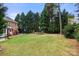 Expansive backyard featuring lush lawn, mature trees, a trampoline, and a swing at 3419 Wylie Meadow Ln, Charlotte, NC 28269