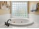 This bright bathroom features an oval soaking tub with black fixtures and a large glass block window at 3419 Wylie Meadow Ln, Charlotte, NC 28269