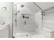 Bathroom with white tiled shower and floors, toilet, and decorative items at 3419 Wylie Meadow Ln, Charlotte, NC 28269