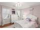 Charming bedroom features wood floors, pink walls, a chandelier, and a white dresser at 3419 Wylie Meadow Ln, Charlotte, NC 28269