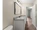 Bathroom with granite countertop, modern vanity, a framed mirror, and wood-look flooring at 426 Holland Memorial Church Rd, Bessemer City, NC 28016