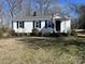 Charming one-story home with white siding, black shutters, and an American flag in a partially wooded area at 426 Holland Memorial Church Rd, Bessemer City, NC 28016