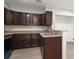 Well-lit kitchen featuring dark wood cabinetry, granite countertops, and stainless steel sink at 4822 Spring Lake Dr # A, Charlotte, NC 28212