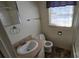 Cozy bathroom with a white sink, toilet, and a window for natural light at 509 California Cir, York, SC 29745