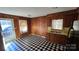 Functional kitchen space with checkered flooring, wood paneling, and stainless-steel sink at 509 California Cir, York, SC 29745