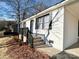 Home exterior with brick siding, black trim, and a wooden porch with brick steps at 511 Newcastle Rd, Gastonia, NC 28052