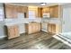 Eat-in kitchen with matching wood cabinetry, white subway tile backsplash, and modern flooring at 511 Newcastle Rd, Gastonia, NC 28052