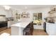 Open-concept kitchen with white cabinets, quartz countertops, wooden floors, and bar seating at 6525 Castlegate Dr, Charlotte, NC 28226