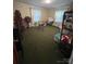 A bedroom with green carpet, wallpapered walls, and two windows with light filtering curtains at 708 Mount Olive Church Rd, Newton, NC 28658