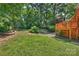 Green backyard with a multi-tiered wooden deck, grassy lawn, and surrounding trees, perfect for outdoor enjoyment at 8000 Greencastle Dr, Charlotte, NC 28210