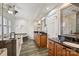 This large bathroom has a glass enclosed shower, a tub, wooden cabinets, and dark granite countertops at 8000 Greencastle Dr, Charlotte, NC 28210