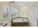 Modern bathroom featuring a large tub with tile surround, and bright window at 8000 Greencastle Dr, Charlotte, NC 28210