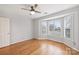 Bright bedroom with hardwood floors, ceiling fan, and large bay window with natural light at 8000 Greencastle Dr, Charlotte, NC 28210