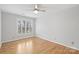 Sunlit bedroom featuring hardwood floors, a ceiling fan, and a window at 8000 Greencastle Dr, Charlotte, NC 28210