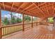 Large covered wooden deck with railing offers an attractive outdoor space and backyard views at 8000 Greencastle Dr, Charlotte, NC 28210