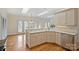 A kitchen with stainless steel appliances, white cabinetry, and a connecting nook with abundant light at 8000 Greencastle Dr, Charlotte, NC 28210