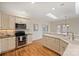 An updated kitchen with stainless steel appliances, a breakfast bar, and modern lighting at 8000 Greencastle Dr, Charlotte, NC 28210