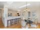 Bright kitchen with stainless steel appliances, bar seating, and an adjacent breakfast nook with stylish chandelier at 8000 Greencastle Dr, Charlotte, NC 28210