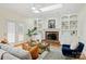 Bright living room featuring built-in shelving, a fireplace, and a ceiling fan for a relaxing atmosphere at 8000 Greencastle Dr, Charlotte, NC 28210